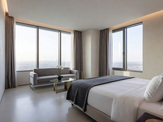 Wide view of a modern luxury hotel room interior with panoramic windows